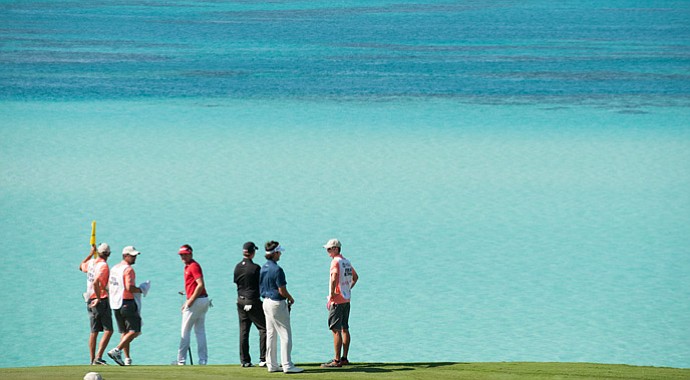 Keegan Bradley, Webb Simpson, and Bubba Watson look out at the ocean on the ninth hole during the final round of play at The Port Royal Golf Club for the 30th Grand Slam of Golf.