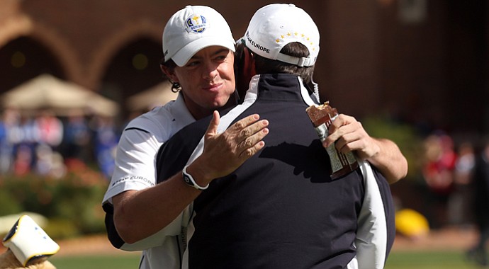 Rory McIlroy of Europe hugs his captain Jose Maria Olazabal on the putting green after arriving late to the golf course during the singles matches for The 39th Ryder Cup at Medinah Country Club.