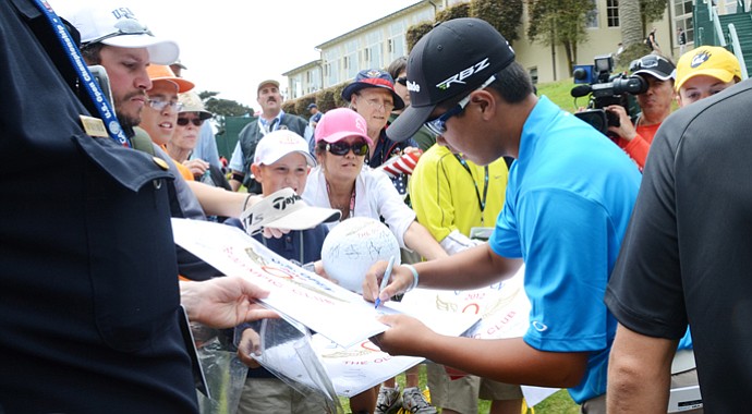 Andy Zhang, 14, signs autographs behind the eighth green at the end of his practice round at The Olympic Club in San Francisco.