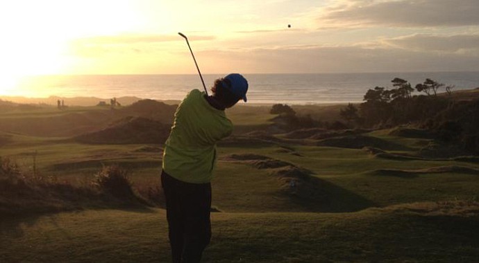 Bradley S. Klein hits a tee ball at dusk at Bandon Preserve in Oregon.