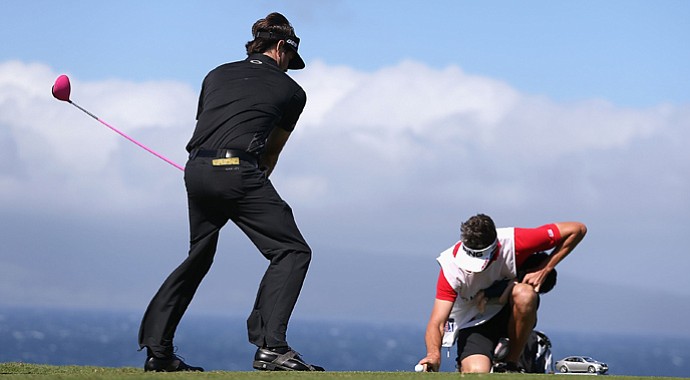 Bubba Watson pretends to tee off as his caddie Ted Scott holds a finger on the ball to keep it from blowing away on the 10th hole during the replay of the first round of the Hyundai Tournament of Champions. The tournament didn't end until Tuesday.