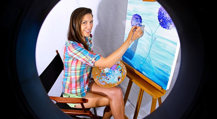 Sandra Gal seen through a ring flash tube as she works on her latest painting.