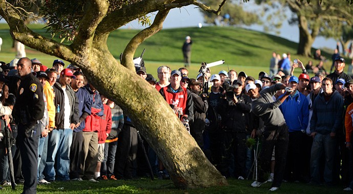 Tiger Woods hits out of the rough on the 4th hole during the final round at the Farmers Insurance Open. He'd chip in for a birdie on his next shot.