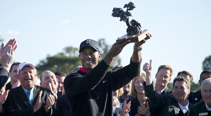 Tiger Woods raises his Farmers Insurance Open trophy at Torrey Pines.