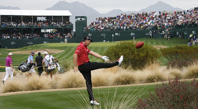 Padraig Harrington punts a football into the grandstands on the 16th hole during the final round of the Waste Management Phoenix Open.