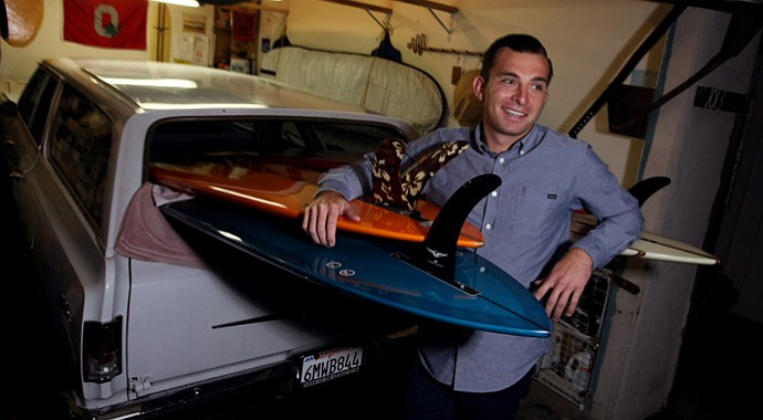 Philip Foster, tour rep with Mitsubishi Rayon poses with some of his surfboards at his home in his garage in Encinitas, Calif.
