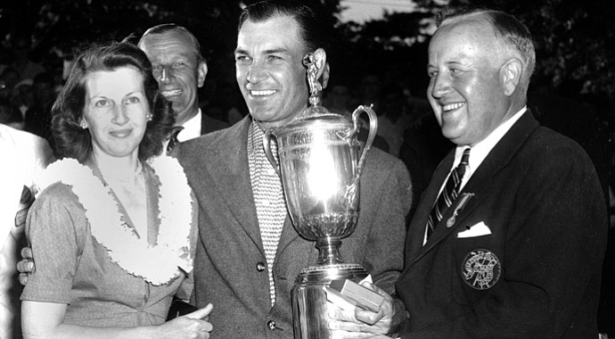 Ben Hogan smiles over a crowd and poses with his wife, Valerie, as he receives the U.S. Open Golf Championship trophy in Ardmore, Pa., on June 11, 1950. Presenting the cup is James D. Standish, Jr., Detroit president of the United States Golf Association.