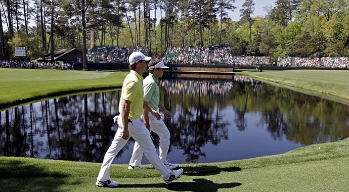 Rory McIlroy walks with amateur Michael Weaver to the 15th green during a practice round for the Masters.