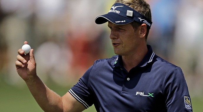 Luke Donald holds up his ball after making par on the second hole during the second round of the Masters.