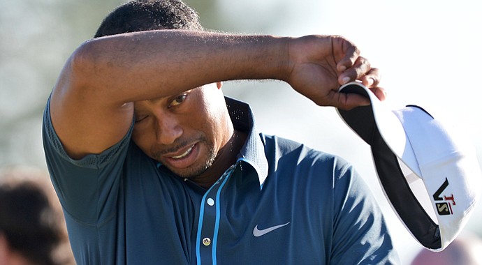 Tiger Woods wipes his brow after a par-save at 18 that helped him record a 2-under 70 and sit four shots off the lead.