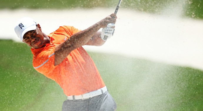 Tiger Woods plays his second shot from a bunker on the first hole during the first round of the Players Championship.