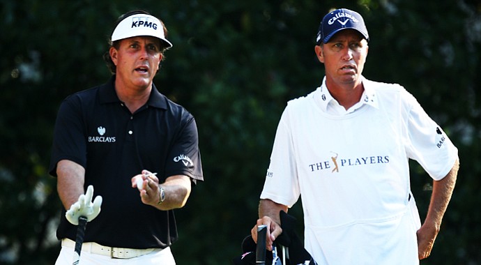 Phil Mickelson and his caddie Jim Mackay stand on the 11th tee on Friday. Mickelson fired a 1-over 73 on Friday, sending himself home a bit earlier than expected.