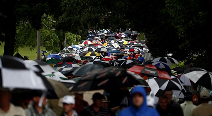 Fans head to the gates after a long day of weather delays that led to the suspension of the first round of play.