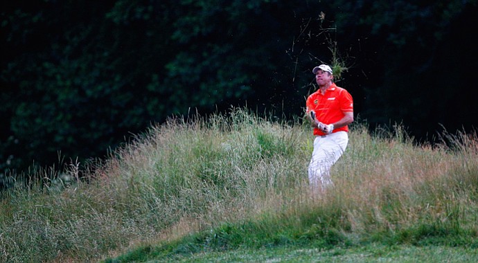 Lee Westwood hits out of the grass on the 12th hole during the first round at the 2013 U.S. Open at Merion Golf Club.