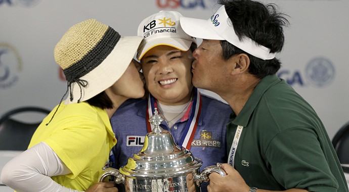 Inbee Park (center) poses for a picture with her trophy while her parents, Sungja Kim (left) and Gungyu Park, kiss her after she won the U.S. Women's Open.