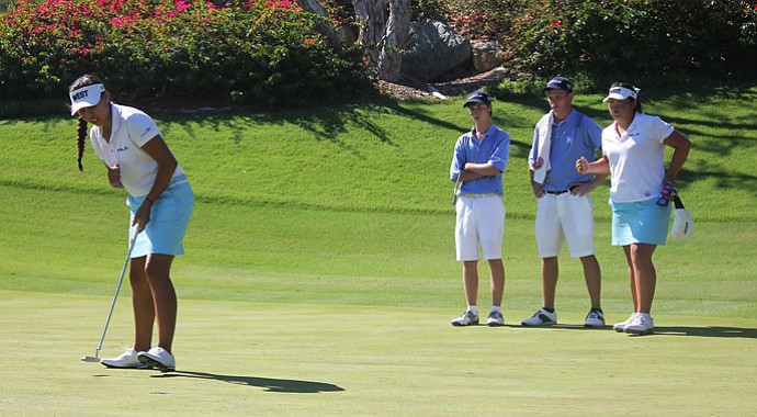 The West's Krystal Quihuis stands over a putt as teammates watch.