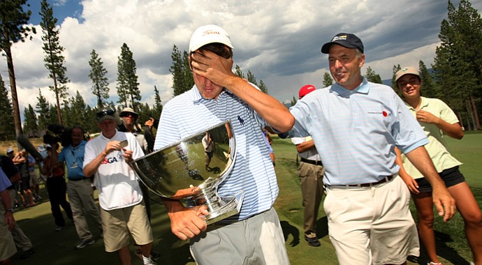 Scottie Scheffler leaves the final hole of the day with the U. S. Junior Amateur trophy during the finals of the 66th U. S. Junior Amateur Championship.