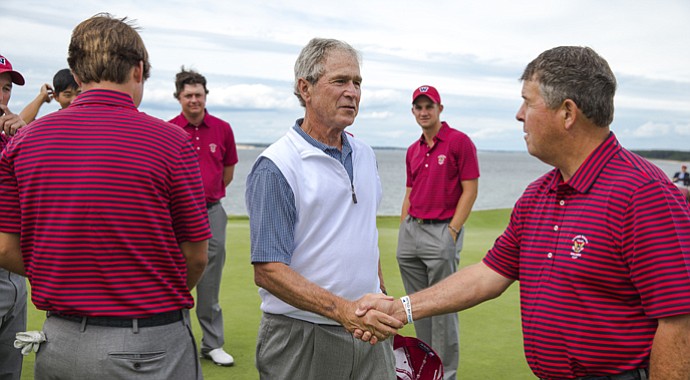 U.S. captain Jim Holtgrieve (right) greets former president George W. Bush on Thursday at National Golf Links.