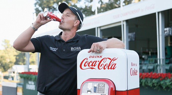 Henrik Stenson poses with an antique Coke machine on the 18th green after winning the Tour Championship.