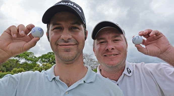 Jorge Campillo of Spain and Colin Nel of South Africa both hold their golf ball with the number 59 after they both shot 59 during the weather-delayed second round of the Nelson Mandela Championship.