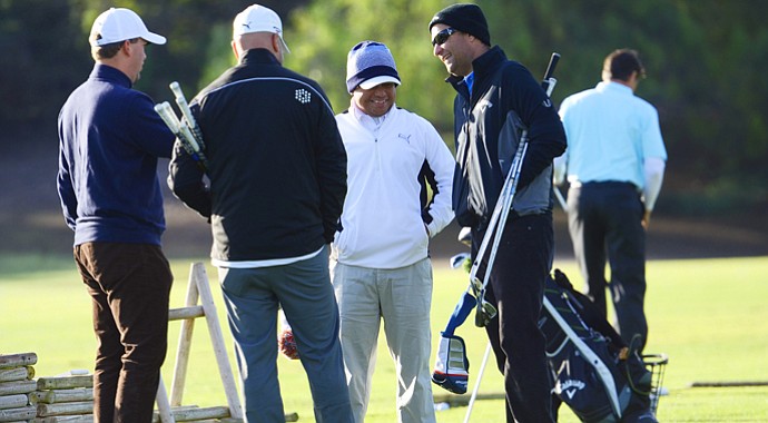 Harry Arnett (left) and Jason Finley (right) of Callaway chat with the team from Cobra, including Jose Miraflor (middle), on the practice range prior to the start of the final round at the Industry Cup in Irvine, Calif.