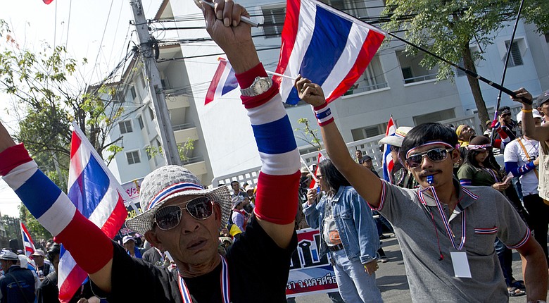Anti-government protesters wave national flags as they block the street in front of the Department of Civil Aviation during a rally in Bangkok on Wednesday.
