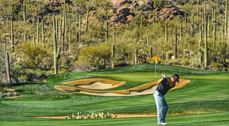 (Note: This image has been created with the use of digital filters) Graeme McDowell plays a shot during practice prior to the start of the WGC-Accenture Match Play at the Golf Club at Dove Mountain.