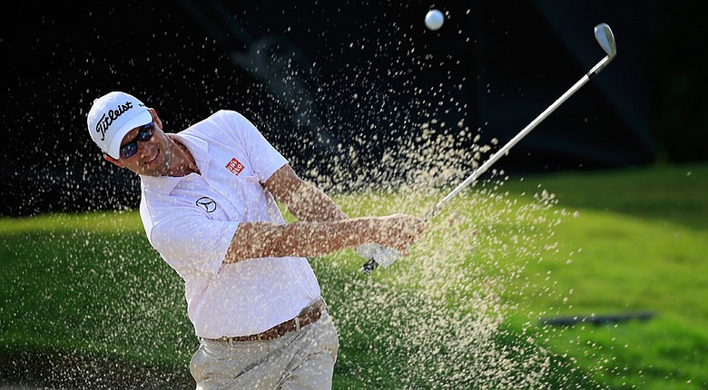 Adam Scott hits a bunker shot on the 11th hole during the weather-delayed first round of the WGC-Cadillac Championship at Trump National Doral.