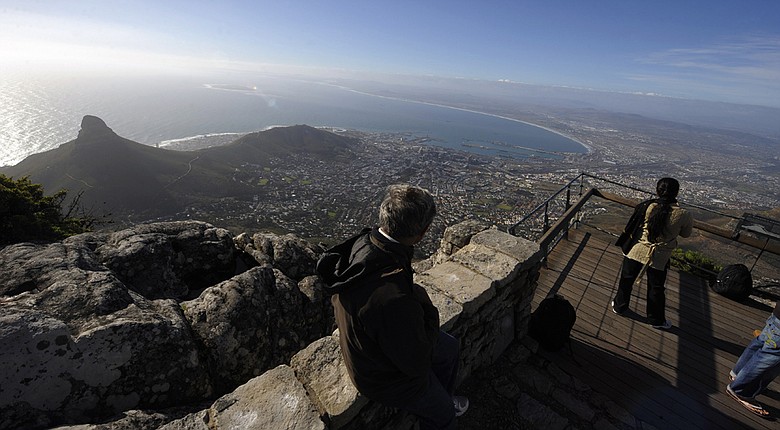 Tourists take pictures of the city of Cape Town as seen from the top of Table Mountain at the arrival station of the Table Mountain cableway. Table Mountain cableway has been running for over 80 years and the cars feature a floor which can rotate while ascending to give passengers a 360-degree panoramic views.