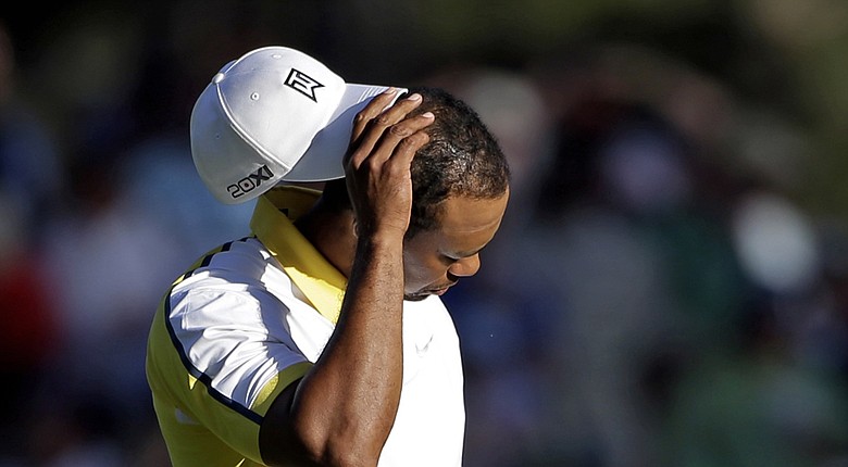 For the first time in 20 years, the Masters won't see Tiger Woods at Augusta National in 2014 (shown here reacting to his ball hitting the pin and going in the water last year).