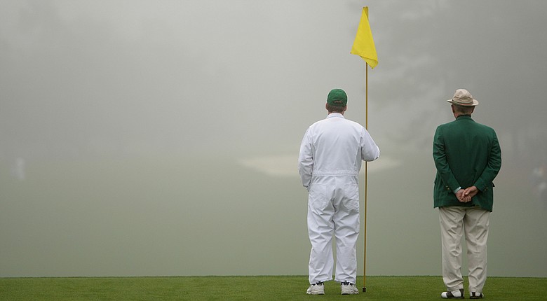 A caddie holds a flag pin during a practice round prior to the start of the 2014 Masters.