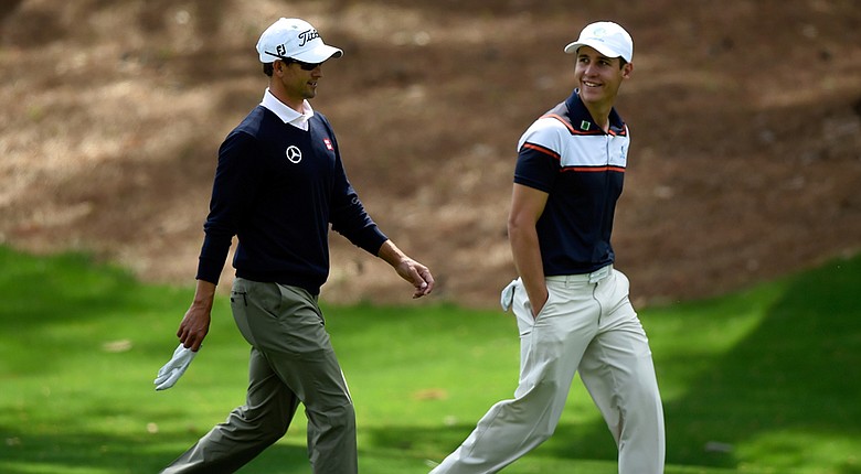 Adam Scott and Oliver Goss (right) walk together during a practice round prior to the start of the 2014 Masters.