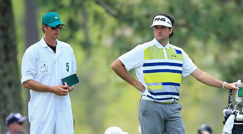 Bubba Watson leans on his bag while caddie Ted Scott checks a yardage during Friday's second round of the 2014 Masters at Augusta National.