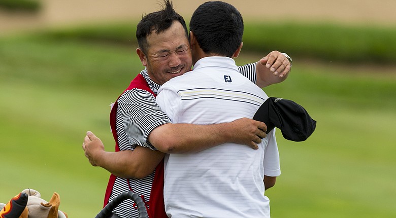 Doug Ghim, right, gets a big hug from his caddie/father, Jeff, after Doug beat Jordan Niebrugge in 23 holes at the 2014 Amateur Public Links.