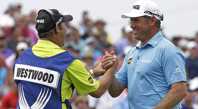 Lee Westwood (right) shakes hands with his caddie, Billy Foster, after firing a 6-under 65 at the 2014 PGA Championship.