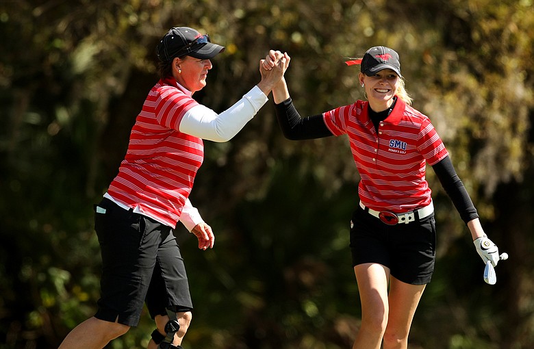 Southern Methodist University head coach Jeanne Sutherland high fives with Jenny Haglund after she chipped in at No. 18 during the Central District tournament at River Wilderness in Parrish.