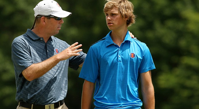 Illinois head coach Mike Small talks with Thomas Detry during the semifinals of match play at the 2013 NCAA Championship at Capital City Club Crabapple Course.