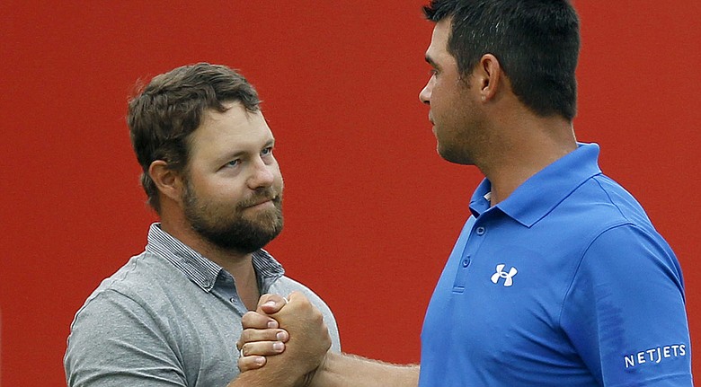 Ryan Moore, left, shakes hands with Gary Woodland after winning a playoff for the CIMB Classic title in Kuala Lumpur, Malaysia.