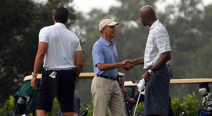 U.S. President Barack Obama (C) shakes hands with former NBA basketball player Alonzo Mourning as he arrives to play golf at Grande Oaks Golf Club in Fort Lauderdale, Florida, on Nov. 9.