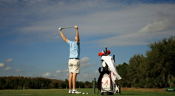 Dru Love stretches on the range prior to Wednesday's practice round at the 2013 PNC Father/Son Challenge. Love and his dad, Davis Love III, are the defending champions.