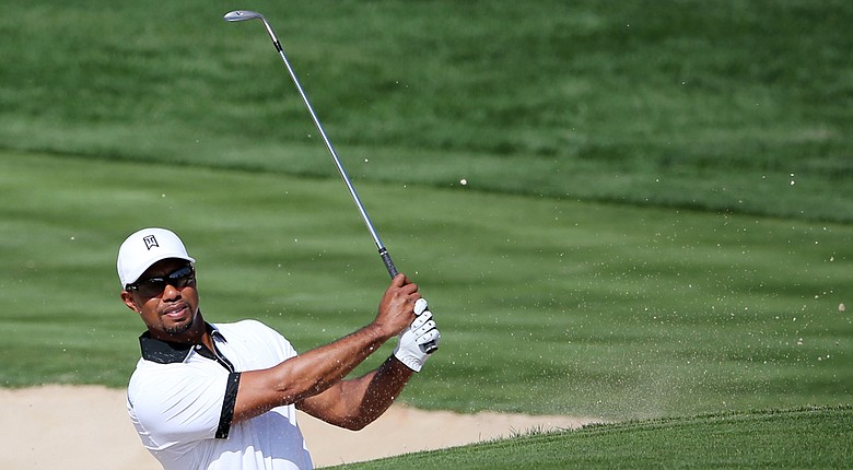 Tiger Woods plays a bunker shot on the third hole during a practice round for the Omega Dubai Desert Classic.