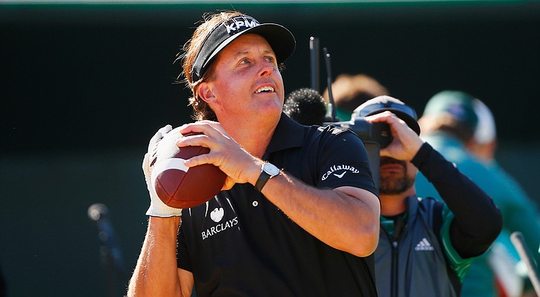 Phil Mickelson throws a football to the crowd on the 16th hole during the third round of the Waste Management Phoenix Open at TPC Scottsdale.