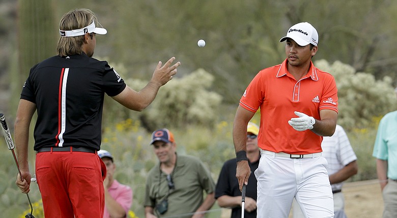 Victor Dubuisson tosses Jason Day's ball to him during their final at the 2014 WGC-Accenture Match Play at Dove Mountain in Marana, Ariz.