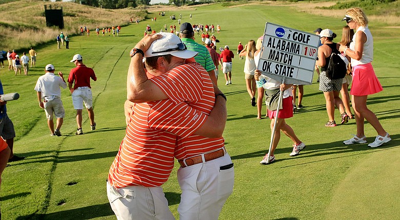 Oklahoma State assistant coach Brian Guetz tries to console Ian Davis after he lost his match to Alabama's Trey Mullinax during the NCAA Men's Division 1 Championship at Prairie Dunes Country Club.