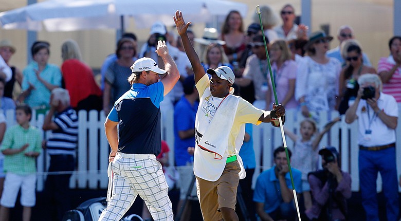 Mikael Lundberg of Sweden celebrates with his caddie after holing a birdie putt in a playoff to win the Lyoness Open.